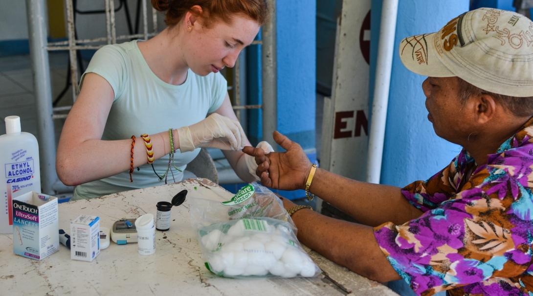 A Transition Year student check a man’s blood sugar levels at an outreach in the Philippines. A student doing her Transition Year in the Philippines gets medical work experience at an outreach.